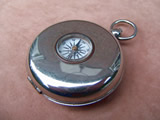 Pocket compass with collapsible stirrup cup inside